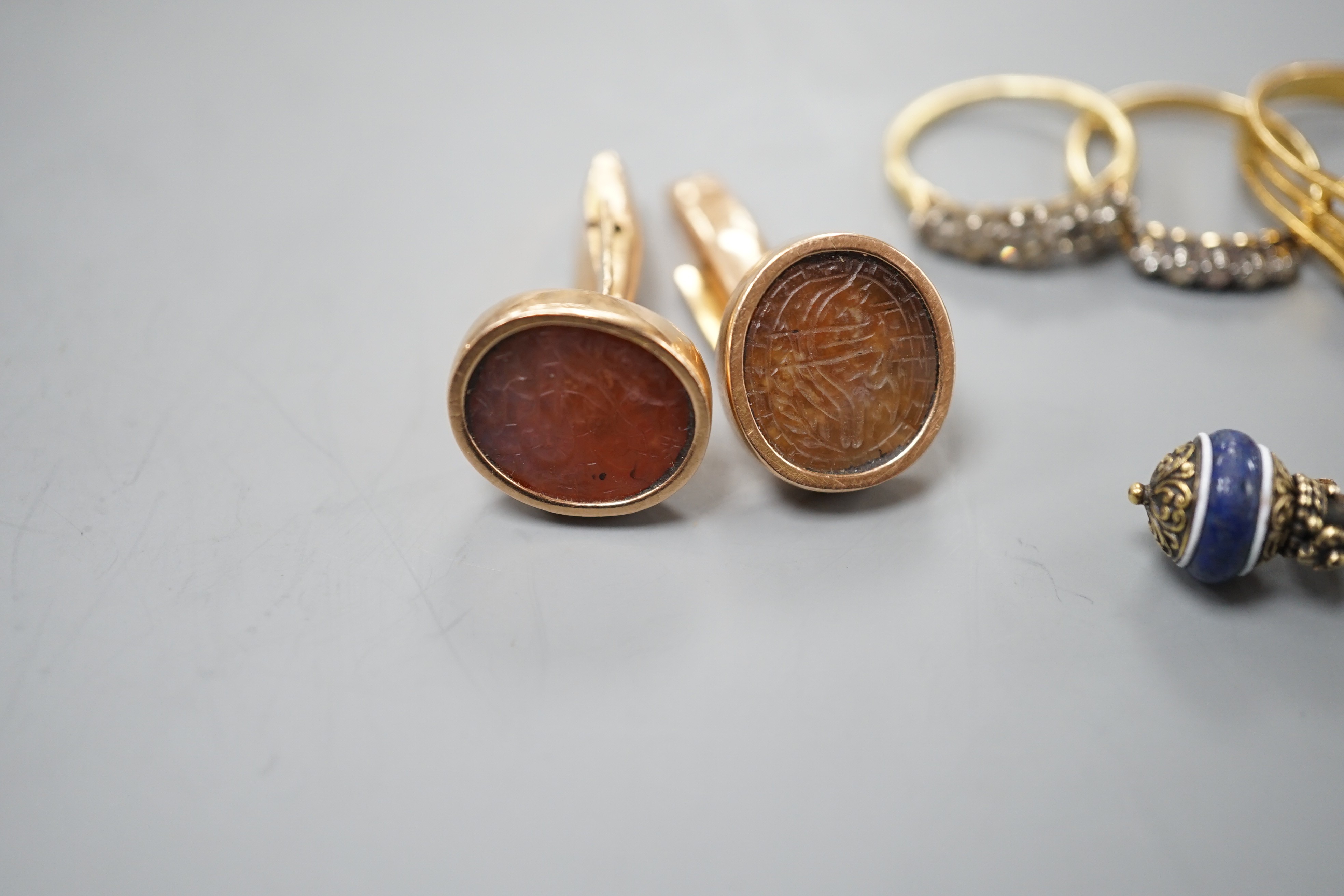 A group of mixed jewellery including two 18ct and diamond half hoop rings, a pair of Middle Eastern yellow metal and talismanic carnelian intaglio cufflinks, a yellow metal and diamond set brooch, a synthetic? ruby set y